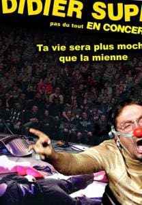 "Didier Super pas du tout en concert. Ta vie sera plus moche que la mienne." Didier Super avec un nez de clown devant une foule.