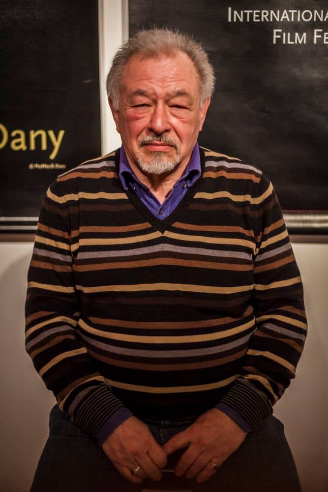 Portrait de Roland Lethem devant des affiches du BIFFF.